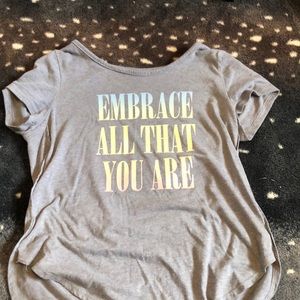 Gray tee with rainbow pastel writing that says “Embrace all that you are”
